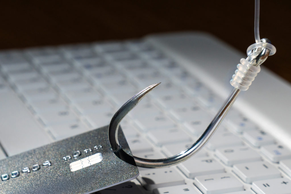 Hameçon accroché à une carte bancaire illustrant une tentative de phishing en ligne.